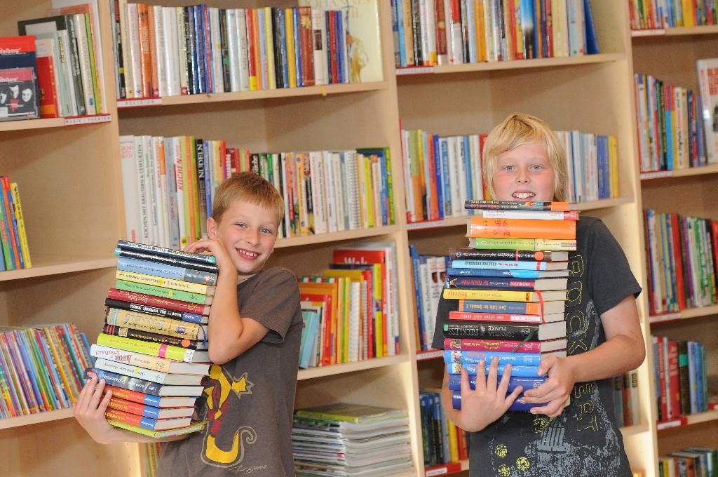 Öffentliche Bibliothek Schnepfau - zwei Buben mit Buchstapeln am Arm